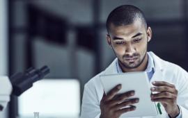 Man in a laboratory looking at a report