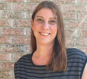 Headshot of Melanie Berubé, CCOA Program Director. She is wearing a striped shirt and smiling.