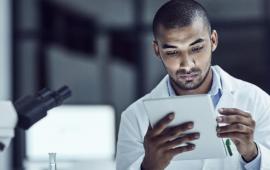 Man in a laboratory looking at a report