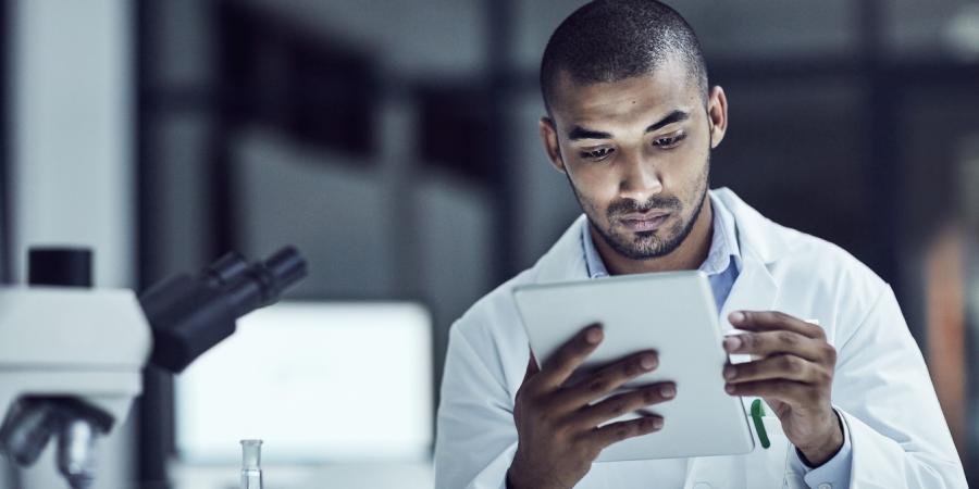 Man in a laboratory looking at a report